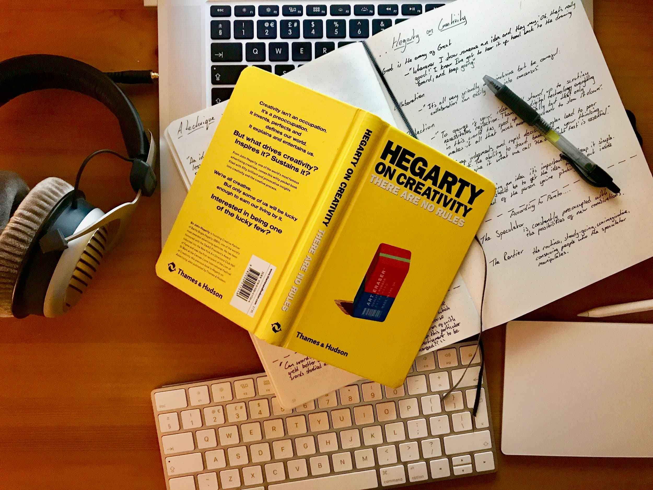 Hegarty on Creativity beside handwritten notes, headphones, and a keyboard.